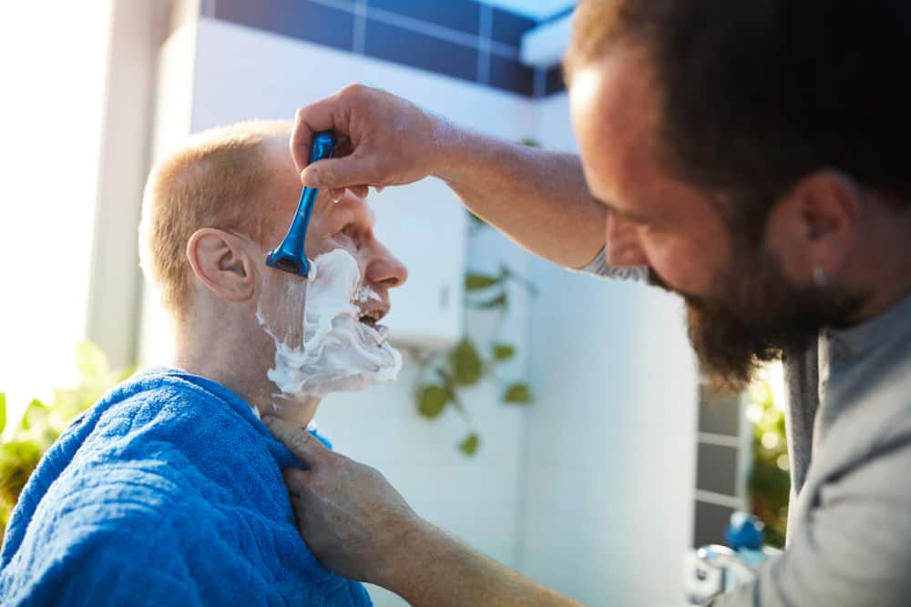 Betreuer rasiert zu pflegenden Bild: Lebenshilfe Südliche Weinstraße